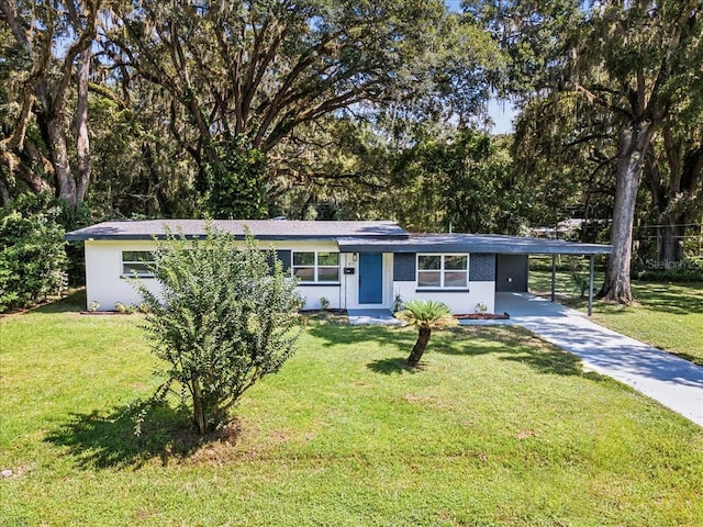 single story home with driveway, a front yard, and a carport