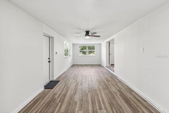 spare room with ceiling fan, baseboards, and wood finished floors