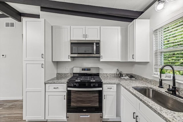 kitchen with vaulted ceiling with beams, stainless steel appliances, white cabinetry, and sink