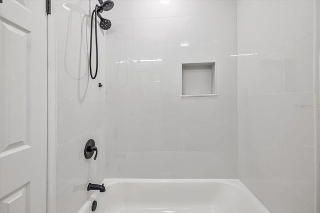 bathroom featuring tiled shower / bath