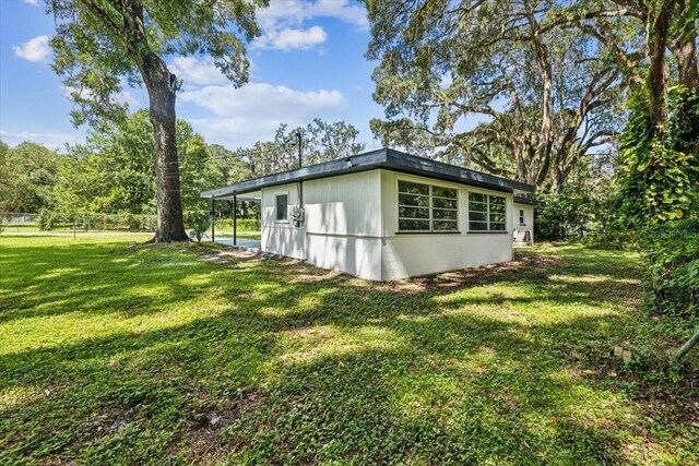 view of home's exterior with a lawn and concrete block siding