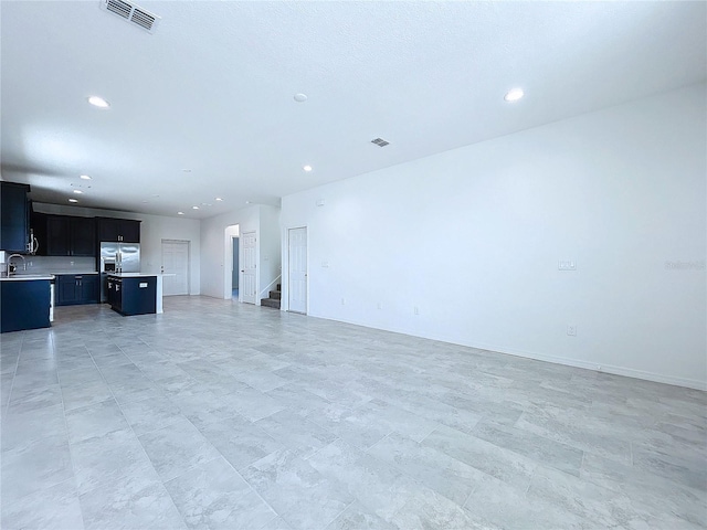 unfurnished living room featuring stairs, visible vents, and recessed lighting