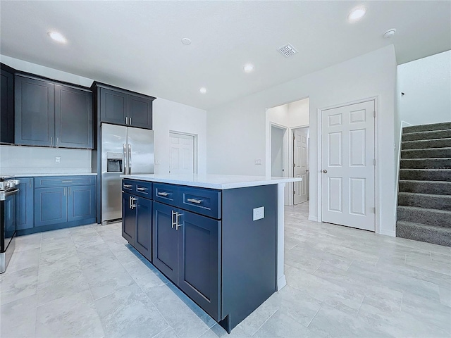 kitchen with stainless steel appliances, recessed lighting, light countertops, visible vents, and a kitchen island