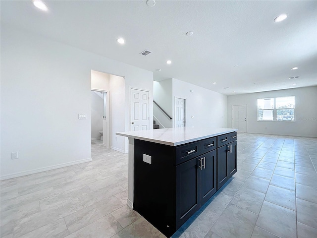 kitchen featuring recessed lighting, light countertops, visible vents, open floor plan, and a kitchen island