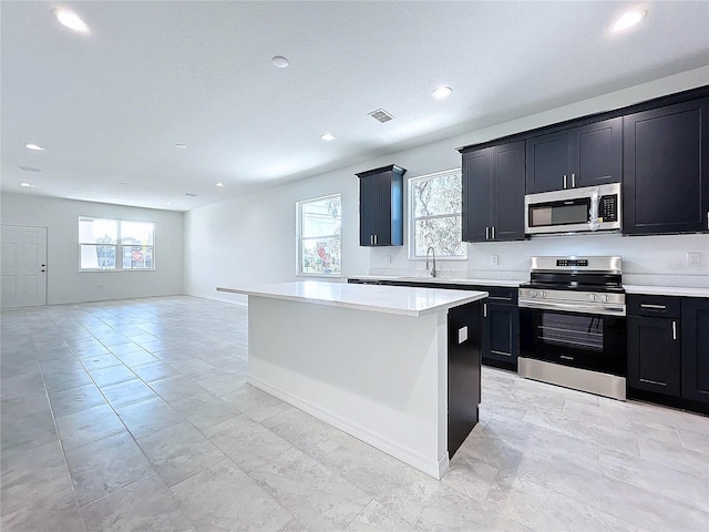 kitchen with visible vents, appliances with stainless steel finishes, light countertops, and open floor plan