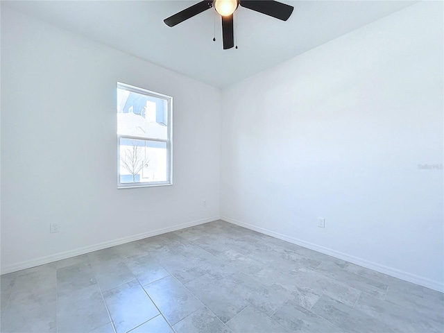 unfurnished room featuring a ceiling fan and baseboards