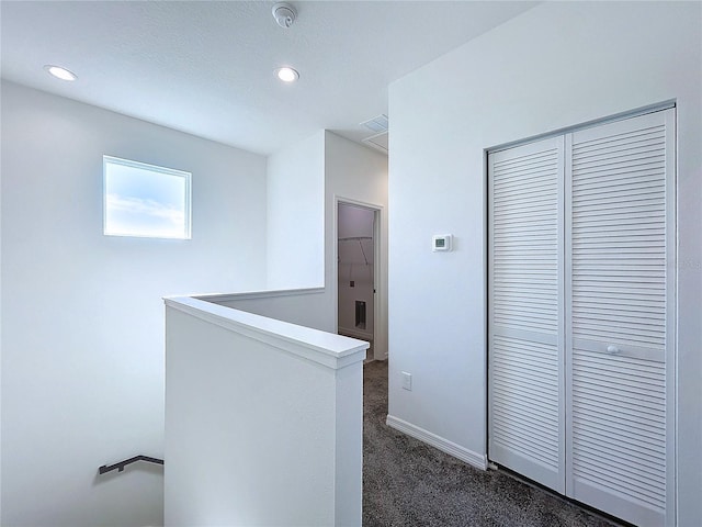 corridor with recessed lighting, baseboards, dark carpet, and an upstairs landing