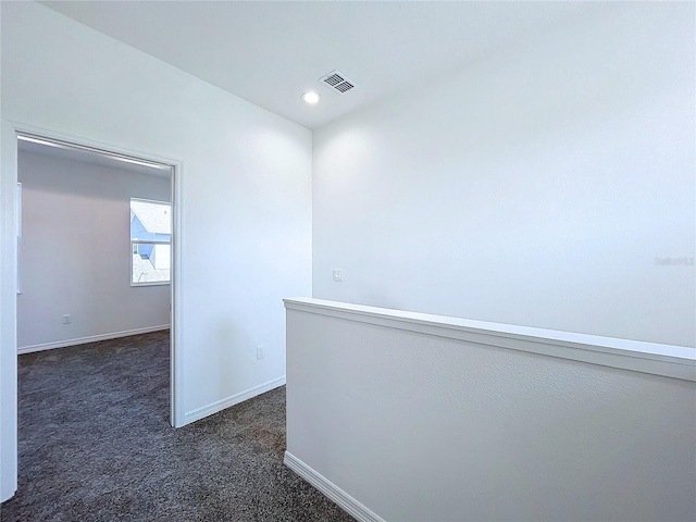 corridor with recessed lighting, visible vents, dark carpet, and baseboards