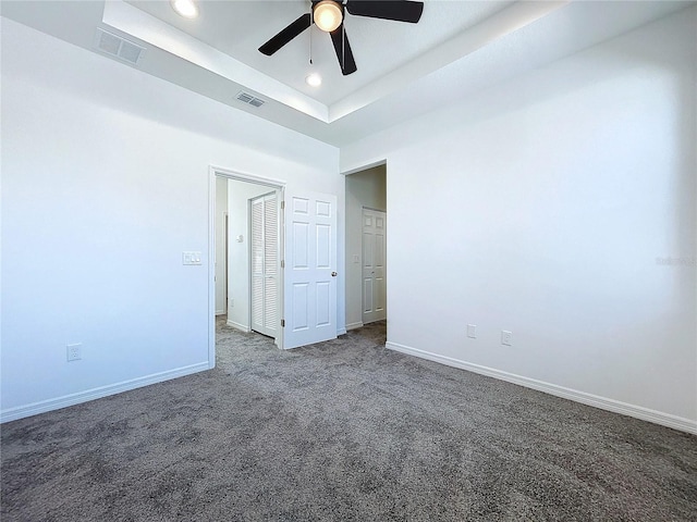 unfurnished bedroom featuring baseboards, visible vents, dark carpet, and recessed lighting