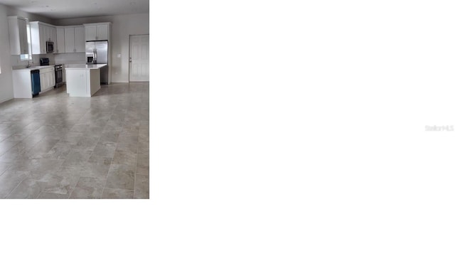 kitchen featuring a center island, light countertops, white cabinetry, a sink, and black appliances