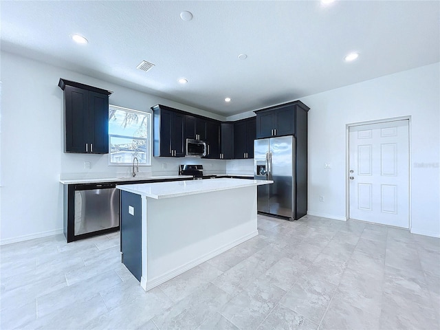 kitchen with appliances with stainless steel finishes, sink, and a kitchen island