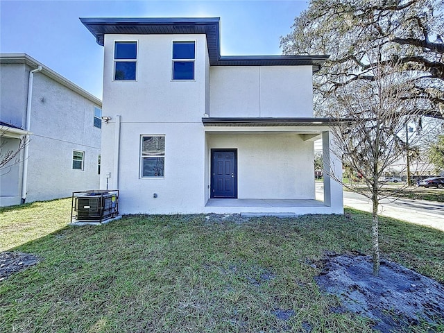 rear view of property with a lawn and central AC