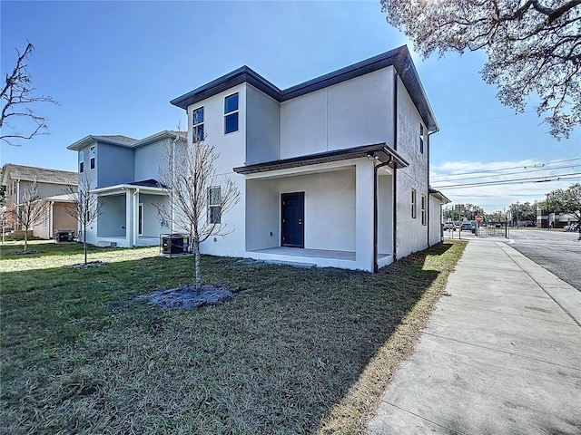 back of property with a lawn and central air condition unit