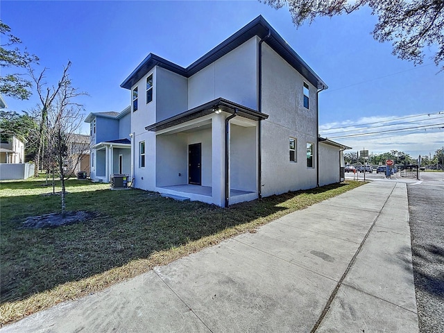 back of house with central AC and a yard