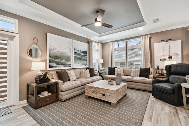 living room featuring ornamental molding, a tray ceiling, ceiling fan, and hardwood / wood-style flooring