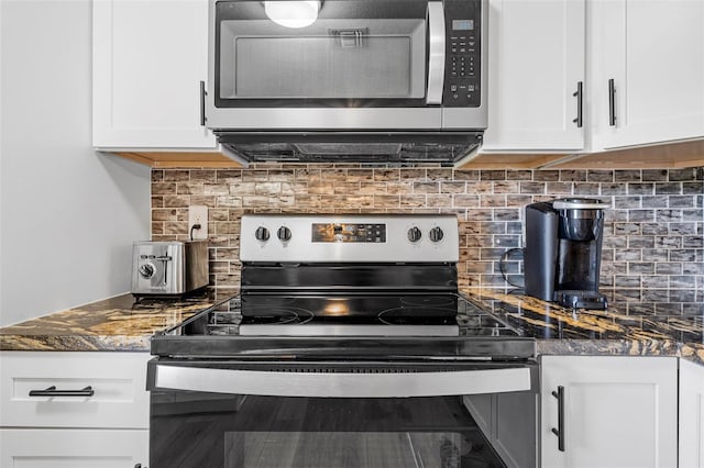 kitchen with white cabinets, appliances with stainless steel finishes, and tasteful backsplash