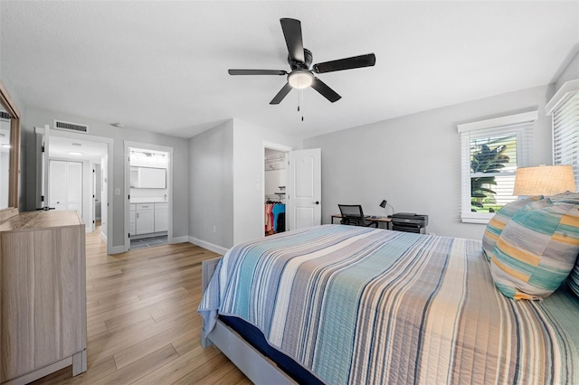 bedroom featuring light hardwood / wood-style floors, ensuite bath, and ceiling fan