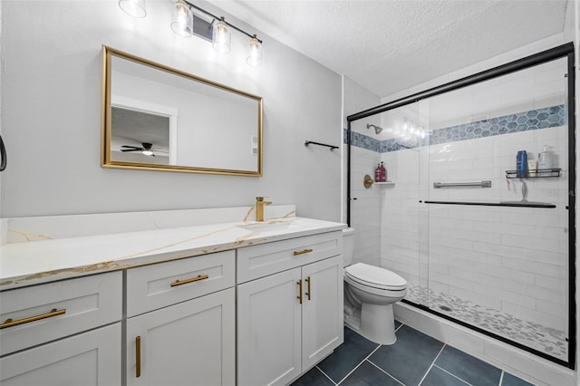 bathroom with tile patterned floors, a textured ceiling, toilet, a shower with door, and vanity