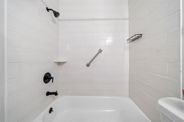 bathroom featuring tiled shower / bath combo and toilet