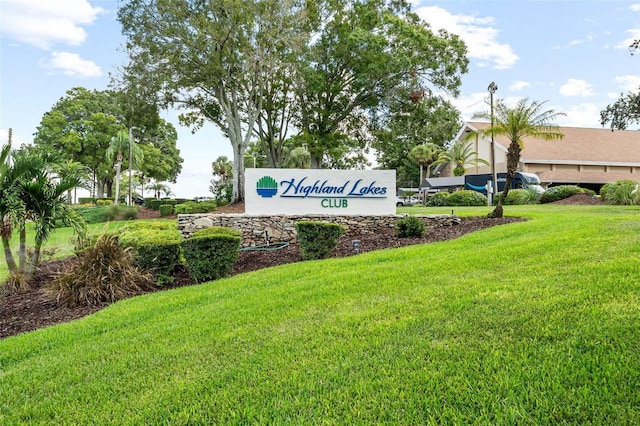 community / neighborhood sign featuring a yard