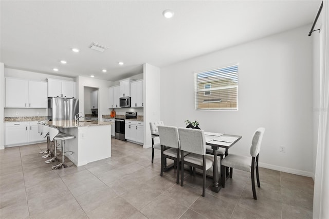 dining space with light tile patterned floors and sink