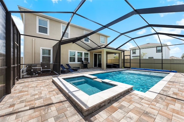 view of swimming pool featuring a patio, an in ground hot tub, and a lanai