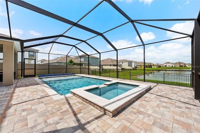 view of pool featuring a patio, a water view, an in ground hot tub, and glass enclosure