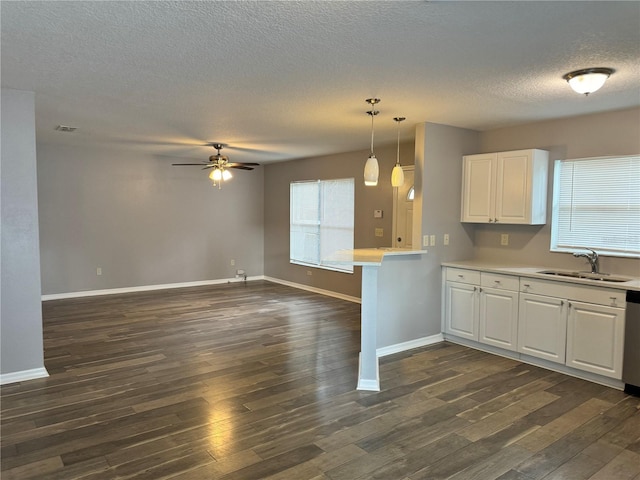 kitchen with pendant lighting, sink, white cabinetry, dark hardwood / wood-style flooring, and a healthy amount of sunlight