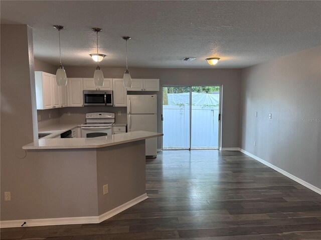 kitchen featuring white cabinets, white appliances, kitchen peninsula, and dark hardwood / wood-style floors