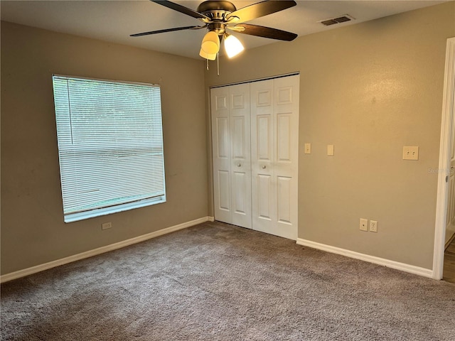 unfurnished bedroom featuring carpet, ceiling fan, and a closet