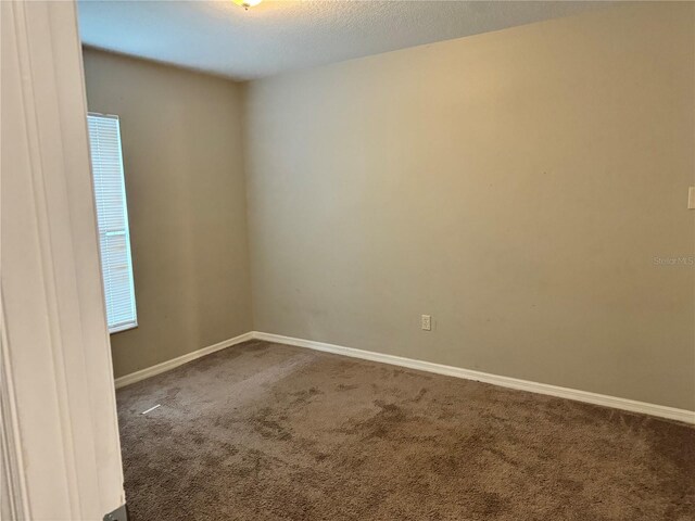 carpeted spare room featuring a textured ceiling