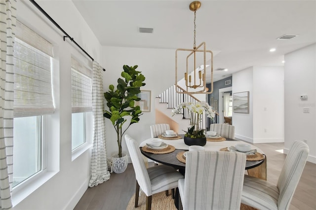 dining space with a chandelier and wood-type flooring