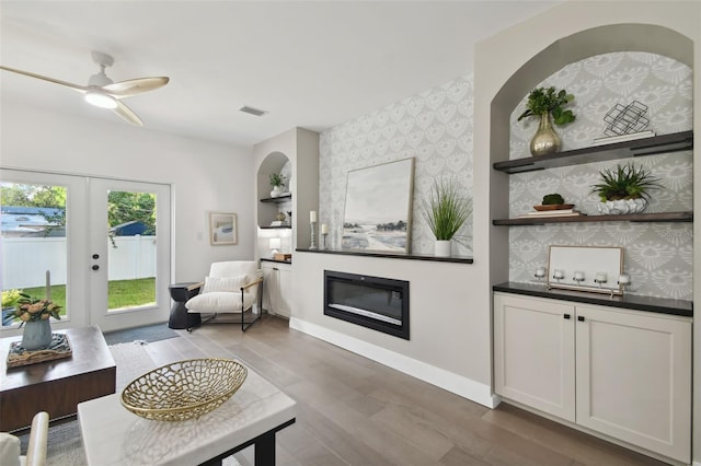 living room featuring french doors, ceiling fan, and wood-type flooring