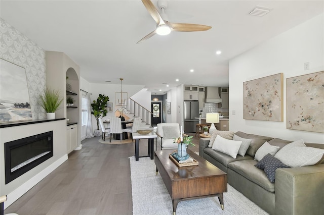 living room with ceiling fan and wood-type flooring