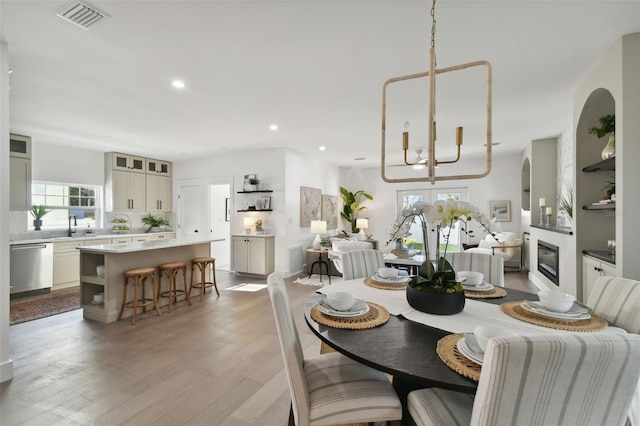 dining area with wood-type flooring, sink, and a chandelier