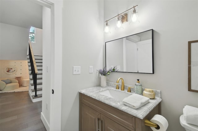 bathroom featuring wood-type flooring, vanity, and toilet