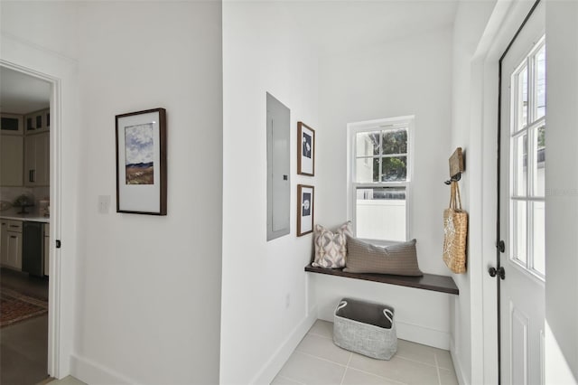 hall featuring light tile patterned floors, electric panel, and a wealth of natural light