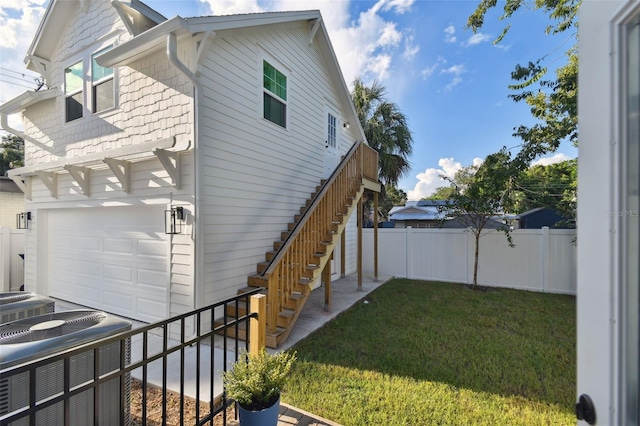 view of side of property featuring a lawn and a garage