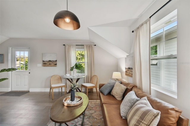 living room featuring dark hardwood / wood-style flooring, a healthy amount of sunlight, and vaulted ceiling