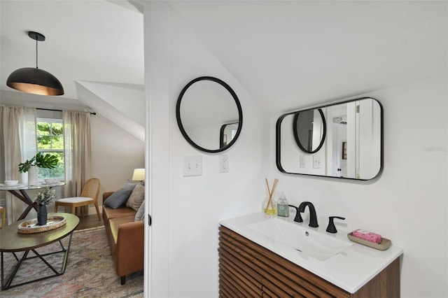 bathroom featuring hardwood / wood-style floors, vanity, and lofted ceiling