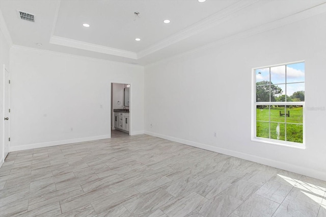 empty room with a raised ceiling and ornamental molding