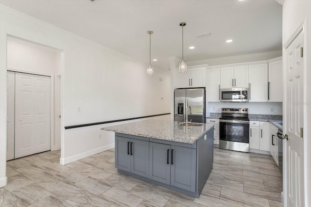 kitchen with an island with sink, stainless steel appliances, white cabinets, and light stone counters