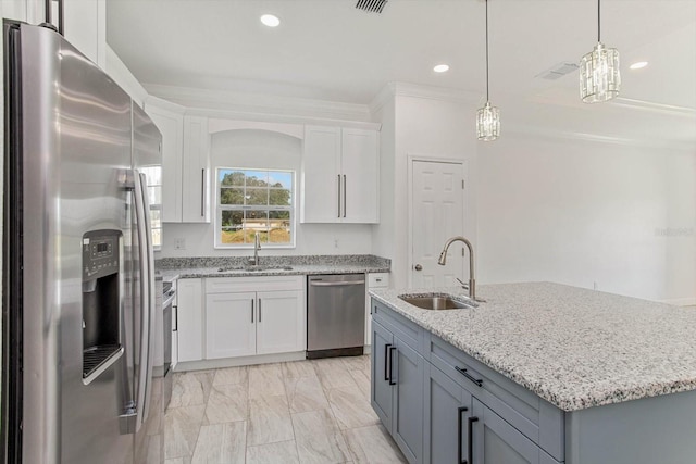 kitchen featuring white cabinets, a center island with sink, stainless steel appliances, and sink