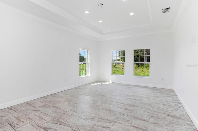 unfurnished room with a tray ceiling and ornamental molding