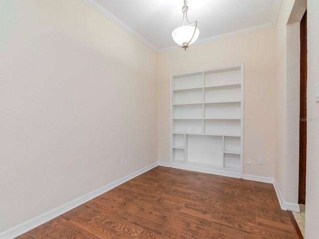 empty room with hardwood / wood-style floors, built in features, and ornamental molding