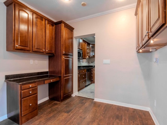 kitchen featuring appliances with stainless steel finishes, dark hardwood / wood-style flooring, dark stone counters, and ornamental molding