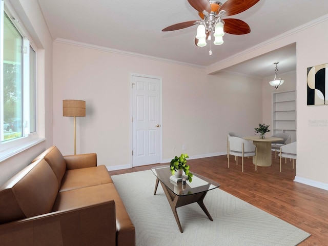 living room with crown molding, built in features, ceiling fan, and hardwood / wood-style floors