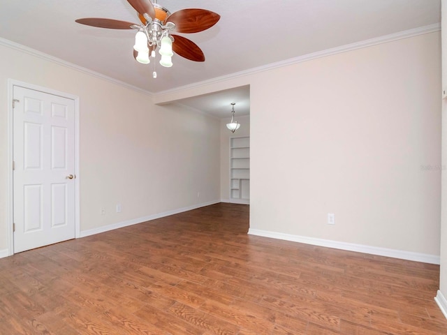 unfurnished room featuring crown molding, built in features, ceiling fan, and hardwood / wood-style flooring