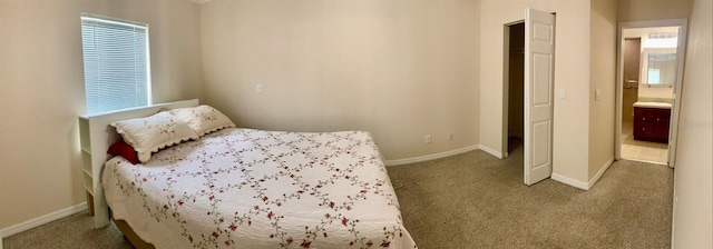 bedroom featuring carpet flooring and connected bathroom