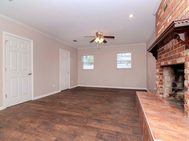 unfurnished living room featuring a fireplace, dark hardwood / wood-style flooring, ceiling fan, and ornamental molding